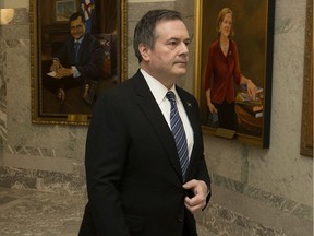 Premier Jason Kenney leaves his office and walks past portraits of former Alberta premiers after delivering a televised address on the COVID-19 pandemic, at the Alberta Legislature on Tuesday.