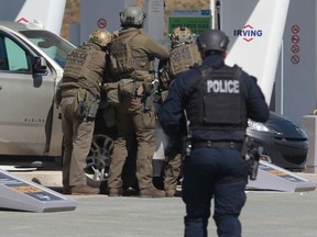 RCMP officers prepare to take a person into custody at a gas station in Enfield, N.S. on Sunday April 19, 2020. A suspect in an active shooter investigation is in custody in Nova Scotia, with police saying several people were harmed before a man wearing police clothing was arrested.