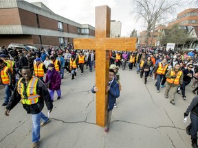 The cross is carried on 18 Ave SW toward its final stations during the 32nd Outdoor Way of the Cross in downtown Calgary in this 2015 file photo. The event was cancelled this year due to COVID-19.