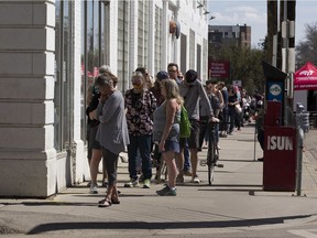 A line of people stretches more than a city block while they physically distance and wait to get into the Downtown Farmers Market on Saturday, May 16, 2020, in Edmonton.