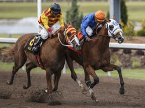 Journeyman ridden by Dane Nelson, right, pulls ahead of Explode, ridden by Amadeo Perez, for the win at the Canadian Derby at Century Mile in Edmonton on August 18, 2019.
