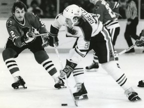 Wayne Gretzky skates with the puck against Chicago Blackhawks defenceman Greg Fox during an NHL playoff game in May 1983.