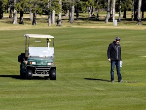 An employee at the Derrick Golf Club in Edmonton checks out the greens on Saturday May 2, 2020. The Alberta government has allowed golf courses to open during the COVID-19 pandemic.