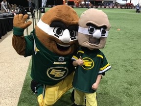 Young fan Hudson Groening, right, poses with the Edmonton Eskimos mascot Punter.