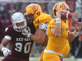 Ottawa Gee-Gees' Alain Pae rushes Queen's Gaels quarterback Nate Hobbs in Ottawa on Sept 4, 2017.