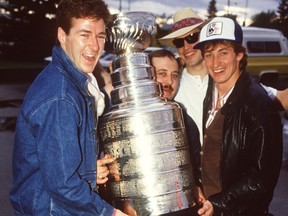 Edmonton Oilers Kevin Lowe, left, equipment manager Lyle 'Sparky' Kulchisky, Mark Messier and Wayne Gretzky hold the Stanley Cup after leaving David's Restaurant in Edmonton on May 21, 1984. The Oilers won their first Stanley Cup on May 19, 1984.