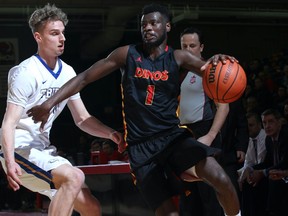 U of C Dinos guard Mambi Diawara, right, drives to the hoop as UBC's Gant Shepard defends during Canada West men's basketball playoff action in Calgary on Feb. 23, 2018.