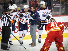 Edmonton Oilers captain Connor McDavid is helped off the ice after colliding with the goalpost against the Calgary Flames at the Scotiabank Saddledome on April 6, 2019.