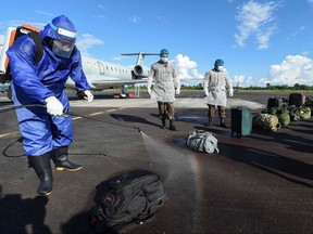 Members of the Brazilian Armed Forces disinfect luggage that arrived on a military flight at the airport, in Tabatinga, Amazonas state, northern Brazil, on June 17, 2020, to assist indigenous population amid the COVID-19 pandemic.