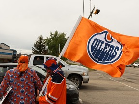 Edmonton Oilers superfan Blair Gladue (left) and his brother Clayton Cardinal celebrate with hockey fans after cheering from the bridge at St. Albert Trail and Anthony Henday Drive after hearing about the resumption of the NHL playoffs in Edmonton on May 26, 2020.