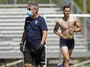 FC Edmonton assistant coach Sean Fleming looks on as defender Amer Didic runs in the background. FC Edmonton held individual player workouts at Clarke Field in Edmonton on Friday June 12, 2020.