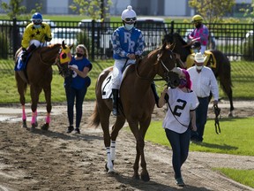 Jockeys prepare to leave the paddock on opening day of the season for Century Mile Racetrack on Sunday, June 21, 2020. No fans were allowed in the stands, just jockeys, horses and trainers.