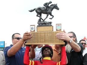 Jockey Rico Walcott holds up the Governor General's Trophy after winning the 85th Canadian Derby at Northlands Park on Aug. 16, 2014.