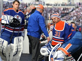 Edmonton Oilers goaltender Dwayne Roloson (left) and Curtis Joseph find their seats at the start of the Heritage Classic alumni game in Winnipeg on Sat., Oct. 22, 2016.