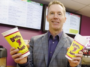 Booster Juice co-founder, president and CEO Dale Wishewan poses for a photo with the company's new cup (left) and old cup in the Booster Juice Test Kitchen at AW Holdings Corp.'s head office in Edmonton on Friday, January 27, 2017.