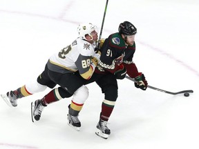 Nate Schmidt (88) of the Vegas Golden Knights hits Taylor Hall (91) of the Arizona Coyotes during an exhibition game prior to the 2020 NHL Stanley Cup Playoffs at Rogers Place on July 30, 2020.