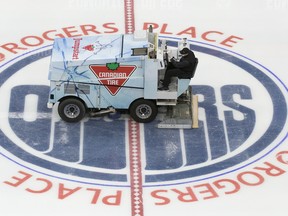 A zamboni driver wearing a face mask floods the ice during the first day of the Edmonton Oilers training camp for the 2019-20 NHL return to play venture at Rogers Place on Monday, July 13, 2020.