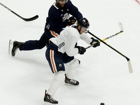 Darnell Nurse (25) battles Connor McDavid (97) during the first day of Edmonton Oilers training camp for the 2019-20 NHL Return to Play initiative at Rogers Place in Edmonton on Monday July 13, 2020.