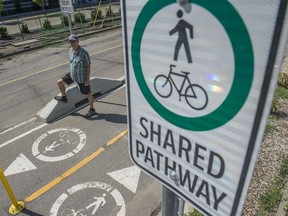 Paths for People chairman Dave Buchanan by a protected bike lane on the north side of 105 Ave/110 Street. Paths for People is calling for the 105 Ave (Columbia Ave) construction project to be paused because it will remove some protected bike lanes. Photo by Shaughn Butts / Postmedia