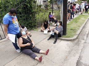 People wait in line at a free COVID-19 testing site provided by United Memorial Medical Center, Sunday, June 28, 2020, at the Mexican Consulate, in Houston.