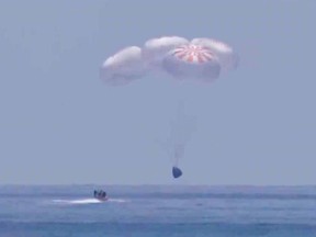 GULF OF MEXICO - AUGUST 2: In this screen grab from NASA TV,  SpaceX 's Crew Dragon capsule spacecraft just before it splashes down in to the water after completing NASA's SpaceX Demo-2 mission to the International Space Station with NASA astronauts Robert Behnken and Douglas Hurley onboard, August 2, 2020 off the coast of Pensacola, Florida in the Gulf of Mexico. The Demo-2 mission is the first launch with astronauts of the SpaceX Crew Dragon spacecraft and Falcon 9 rocket to the International Space Station as part of the agency's Commercial Crew Program. The test flight serves as an end-to-end demonstration of SpaceXs crew transportation system. Behnken and Hurley launched at 3:22 p.m. EDT on Saturday, May 30, from Launch Complex 39A at the Kennedy Space Center. A new era of human spaceflight is set to begin as American astronauts once again launch on an American rocket from American soil to low-Earth orbit for the first time since the conclusion of the Space Shuttle Program in 2011.