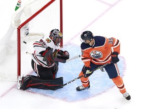 Corey Crawford #50 of the Chicago Blackhawks is unable to stop a shot by Connor McDavid(not pictured) as Alex Chiasson #39 of the Edmonton Oilers looks on in Game One of the Eastern Conference Qualification Round prior to the 2020 NHL Stanley Cup Playoffs at Rogers Place on August 01, 2020 in Edmonton.