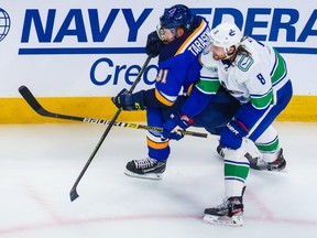 St. Louis Blues right wing Vladimir Tarasenko (91) and Vancouver Canucks defenceman Christopher Tanev (8) battle for the puck during the second period in Game 1 of the first round of the 2020 Stanley Cup Playoffs at Rogers Place.