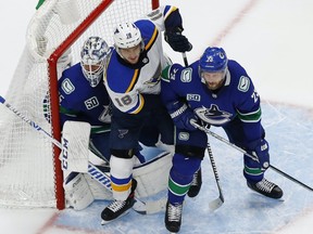 Blues center Robert Thomas (18) battles for position against Vancouver Canucks goaltender Jacob Markstrom (25) and defenseman Alexander Edler (23) during the third period in game six of the first round of the 2020 Stanley Cup Playoffs at Rogers Place on Aug. 21, 2020.