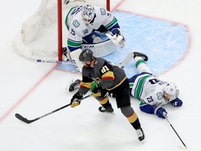Vegas Golden Knights center Jonathan Marchessault (81) controls the puck in front of Vancouver Canucks defenseman Alexander Edler (23) and goaltender Jacob Markstrom (25) during the second period in Game 2 of the second round of the 2020 Stanley Cup Playoffs at Rogers Place on Aug. 25, 2020.