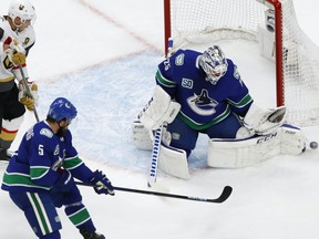 Vancouver Canucks goalie Jacob Markstrom (25) makes a save in front of Vegas Golden Knights right wing Reilly Smith (19) during the first period in Game 3 of the second round of the 2020 Stanley Cup Playoffs at Rogers Place on Aug. 29, 2020.