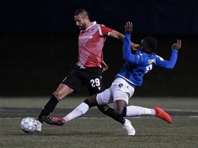 FC Edmonton midfielder Mele Temguia challenges Cavalry FC midfielder Marcus Haber for the ball in Canadian Premier League Island Games play in Charlottetown, P.E.I., on Aug. 20, 2020.