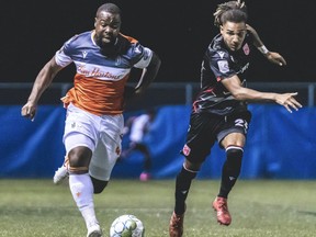 Cavalry FC fullback Mohamed Farsi (R) competes for a ball against  Forge FC defender Dominic Samuel (L) on Thursday, August 13, 2020 during the opening game of the Canadian Premier League Island Games soccer action in Charlottetown, Prince Edward Island.
