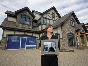 Casey Lane poses with a photo of her son Lorcan Lane outside the $2 million 2020 Covenant DreamLife Lottery home, 5621 Cautley Cove SW, in Edmonton Thursday Aug. 13, 2020. Lorcan was born premature Nov. 5, 2018. Photo by David Bloom