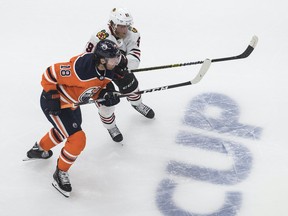 Edmonton Oilers forward James Neal (18) and Chicago Blackhawks forward Drake Caggiula (91) battle for the puck during second period NHL playoff action in Edmonton on Saturday, Aug. 1, 2020.