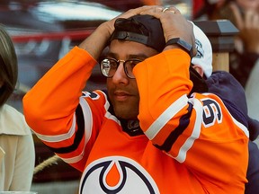 An Edmonton Oilers fan reacts to the team's loss to the Chicago Blackhawks and elimination from NHL playoff contention in downtown Edmonton on Friday, Aug. 7, 2020.