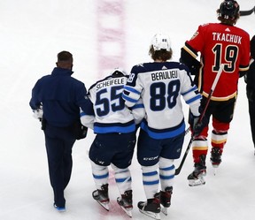 Jets forward Mark Scheifele is helped off of the ice by Nathan Beaulieu after a hard hit against the Calgary Flames in Game One of their playoff series last night.