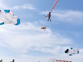 A child is pulled up in the air by a kite at an International Kite Flying Festival, in Hsinchu, Taiwan August 30, 2020 in this screen grab obtained from a social media video. Facebook