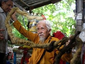 Nguyen Van Chien, 92, sits for a portrait to show his 5-meter long hair which, according to him, has not been cut for nearly 70 years, at his home in Tien Giang province, Vietnam , August 21, 2020.
