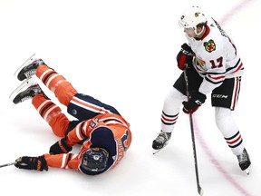 Andreas Athanasiou (28) of the Edmonton Oilers falls to the ice after colliding with Dylan Strome (17) of the Chicago Blackhawks during Game 1 of the Eastern Conference qualification round at Rogers Place on August 01, 2020.