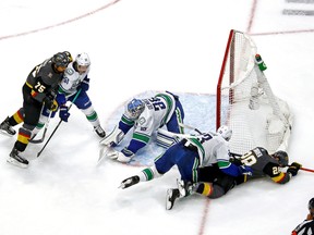 EDMONTON, ALBERTA - SEPTEMBER 01:  Alexander Edler of the Vancouver Canucks checks William Carrier of the Vegas Golden Knights as Thatcher Demko covers up the puck in Game 5 of the Western Conference second round of the 2020 NHL Stanley Cup Playoffs at Rogers Place on Sept. 01, 2020.