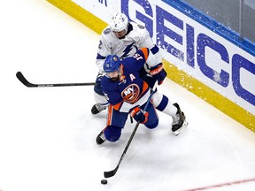 Cal Clutterbuck (No. 15) of the New York Islanders is defended by Luke Schenn (No. 2) of the Tampa Bay Lightning during the first period in Game 3 of the Eastern Conference Final during the 2020 NHL Stanley Cup Playoffs at Rogers Place on September 11, 2020.