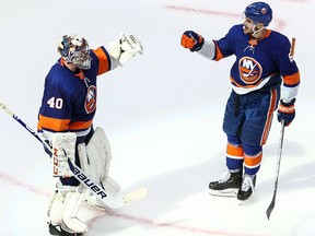 Semyon Varlamov (40) and Ryan Pulock (6) of the New York Islanders celebrate their 5-3 victory over the Tampa Bay Lightning in Game 3 of the Eastern Conference final during the 2020 NHL Stanley Cup Playoffs at Rogers Place on Sept. 11, 2020.