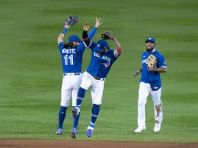 Blue Jays' Bo Bichette , Jonathan Villar and Teoscar Hernandez (right) celebrate after clinching a playoff spot following a victory over the New York Yankees at Sahlen Field.