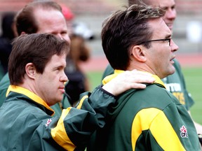 Edmonton Football Club locker-room attendant Joey Moss puts his hand on the shoulder of equipment manager Dwayne Mandrusiak during 2010 training camp at Commonwealth Stadium.