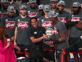Miami Heat head coach Erik Spoelstra hands the Eastern Conference Championship trophy to forward Bam Adebayo (13) after defeating the Boston Celtics at AdventHealth Arena.
