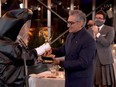 This handout picture shows Canadian actor Eugene Levy receiving his Emmy while his son actor/director/writer Daniel Levy watches during the 72nd Primetime Emmy Awards ceremony held virtually on Sunday, Sept. 20, 2020.