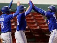 Teoscar Hernandez of the Blue Jays, right, celebrates with Cavan Biggio and Derek Fisher after hitting a three-run home run against the Red Sox during the 10th inning at Fenway Park in Boston, Thursday, Sept. 3, 2020.