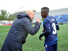 FC Edmonton head coach Jeff Paulus talks with defender Jeannot Esua on the way to a 2-1 win over the Halifax Wanderers in a Canadian Championship match at Clarke Field on July 1, 2019.