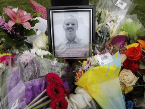 An impromptu memorial for Dr. Walter Reynolds, who died after he was attacked in an examination room rests outside the Village Mall walk-in clinic in Red Deer, Alta., on August 11, 2020. A man accused of killing a family doctor at a medical clinic in central Alberta is scheduled to appear in court today. Deng Mabiour is charged with first-degree murder in death of Dr. Walter Reynolds.