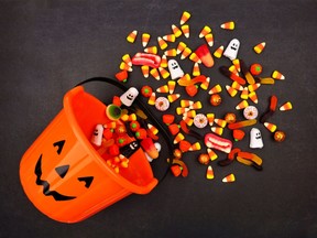 Halloween Jack o Lantern pail with spilling candy, above view on a dark background. Getty Images/iStockphoto